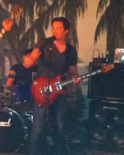 Marco en concert, guitare électrique en main, au chant