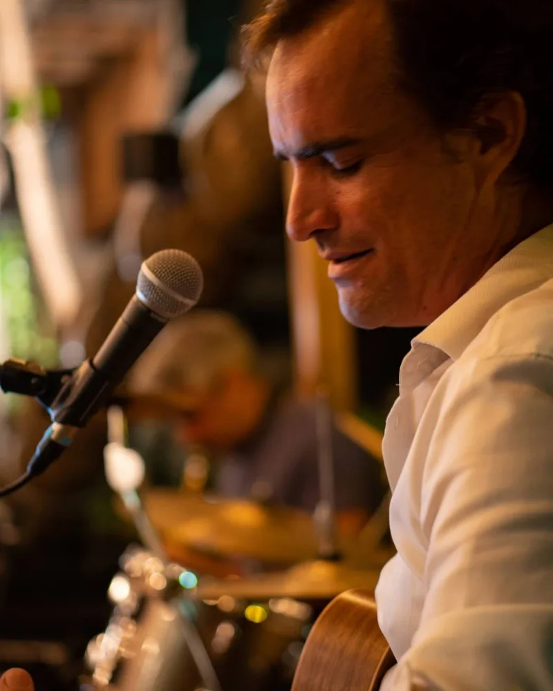 Vincent en concert, guitare acoustique en main, au micro